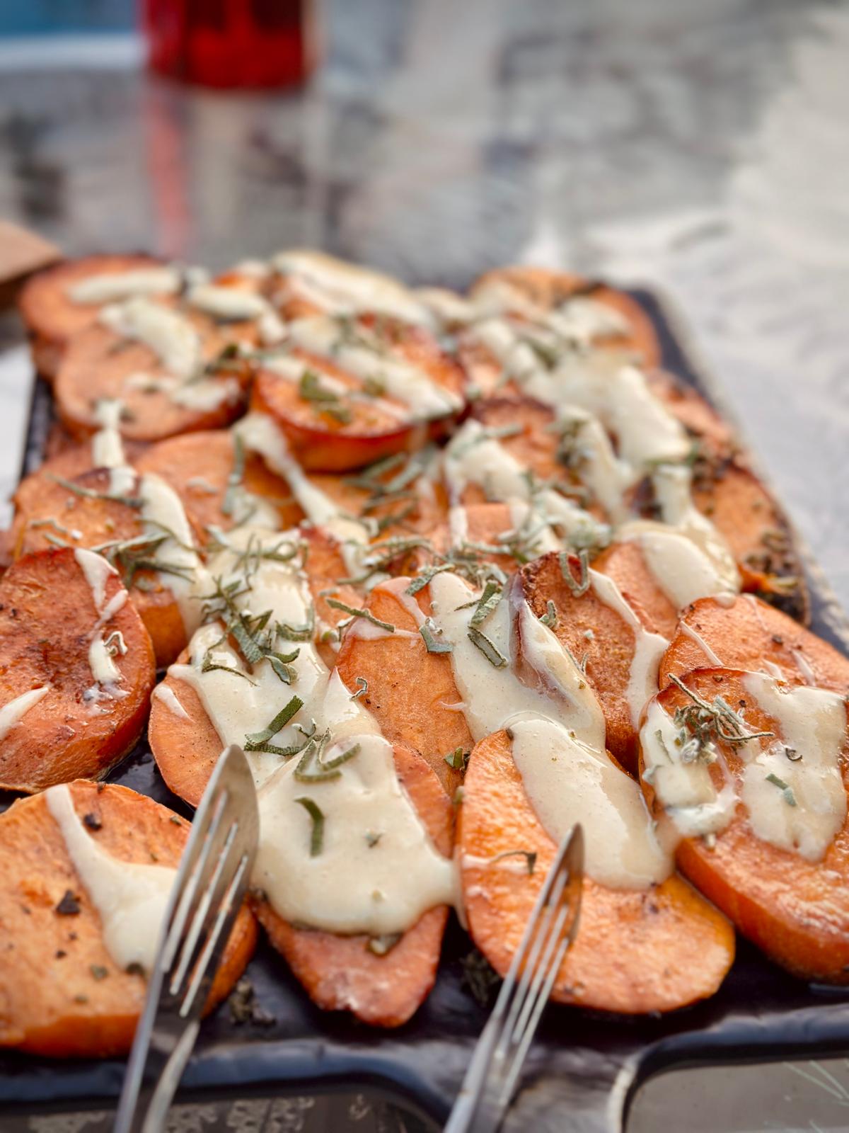 Roasted sweet potato rounds with melted cheese and fresh herbs
