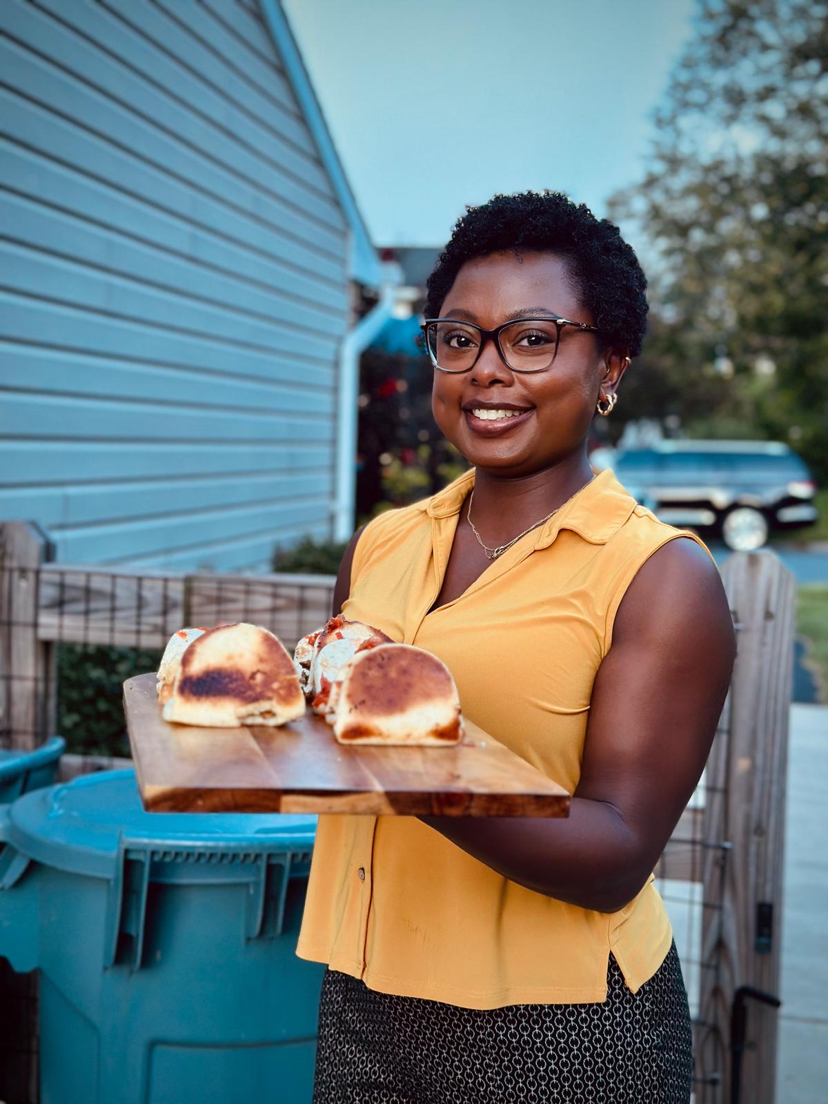Serving fresh-made sandwiches on a wooden board at a P&D Gourmet Creations event
